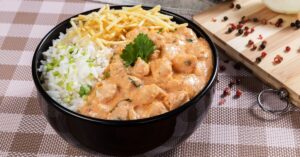 Strogonoff de frango cremoso servido com arroz branco e batata palha