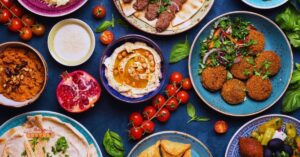 Mesa com comida árabe com pratos típicos como hummus, falafel e tabule, destacando a riqueza da culinária árabe