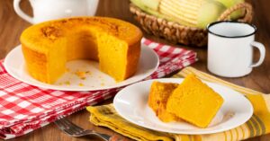 Bolo de milho fofinho cortado em fatias ao lado de uma xícara de café