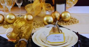 Decoração de mesa para a ceia de Ano Novo com tema dourado, representando prosperidade, acompanhada de elementos simbólicos para atrair sorte, como uma pera decorativa e detalhes sofisticados, ideal para um jantar especial com receitas tradicionais.