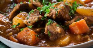 Ensopado de carne com mandioca servido em um prato fundo com cheiro-verde por cima