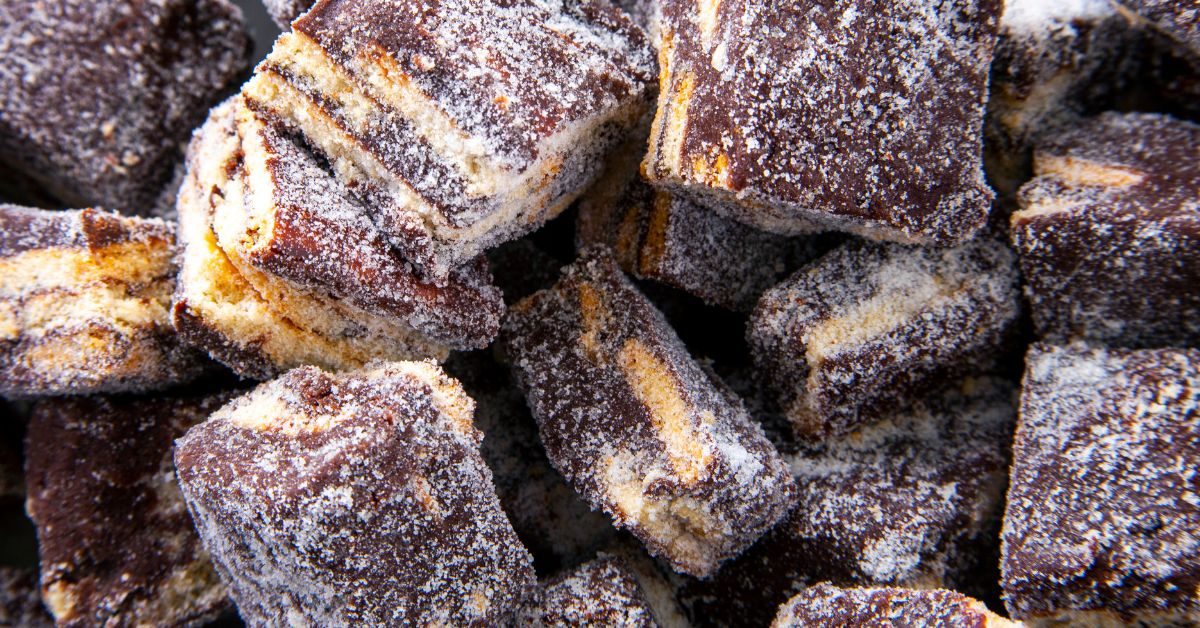 Palha Italiana cortada em pequenos pedaços, com camadas de brigadeiro e biscoito maisena, polvilhada com açúcar refinado.